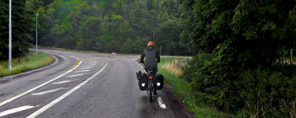 fietsen in de regen over asfalt en groene bossen